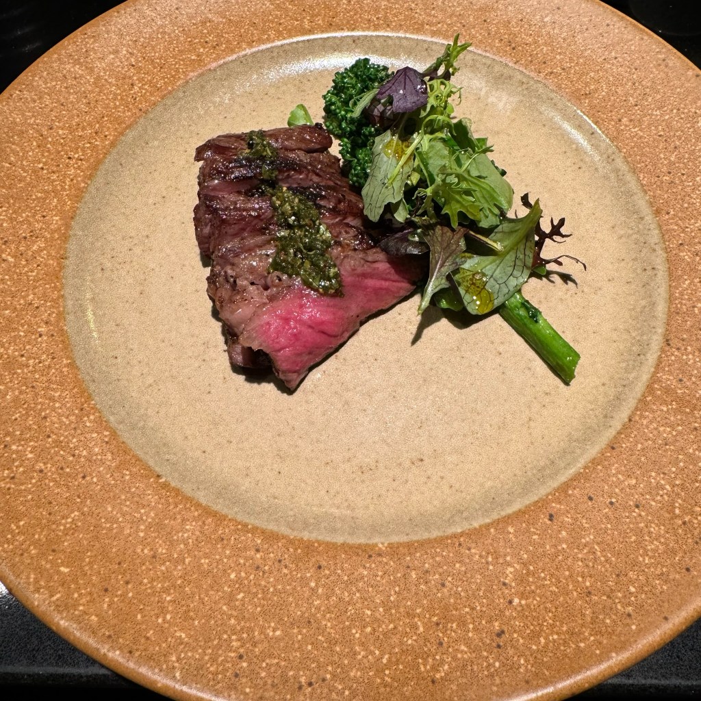 Wagyu with broccolini on a plate.